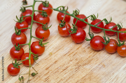 Some red cherry tomatoes in wooden background