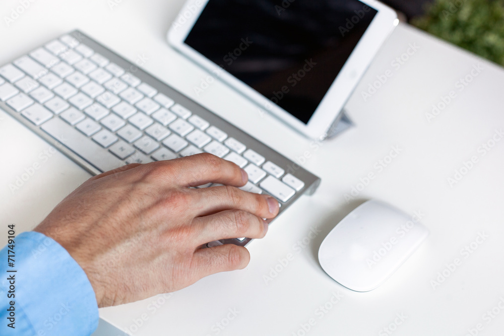 Tablet on desktop with hands on keyboard Tablet on desktop with hands on keyboard