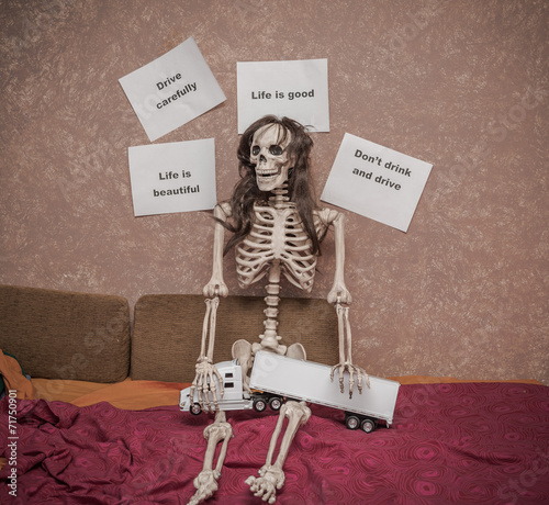 safety messages above sitting skeleton holding truck model