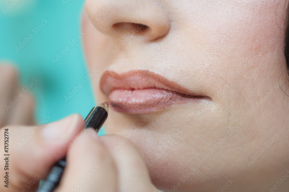 Closeup of woman applying lipstick