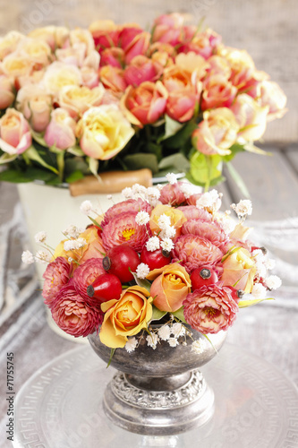 Bouquet of roses and chrysanthemums in vintage silver vase