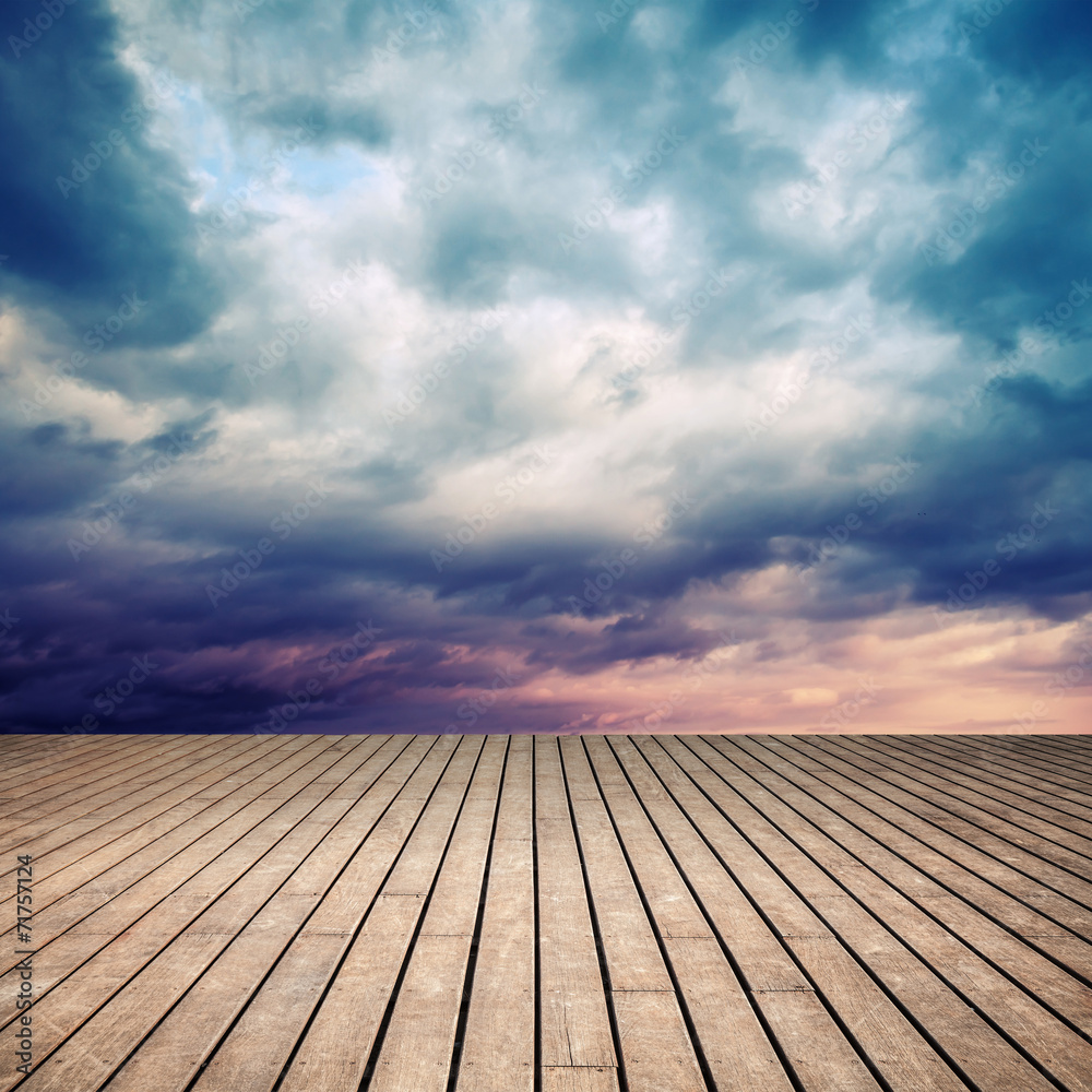 Wooden floor with perspective and stormy sky
