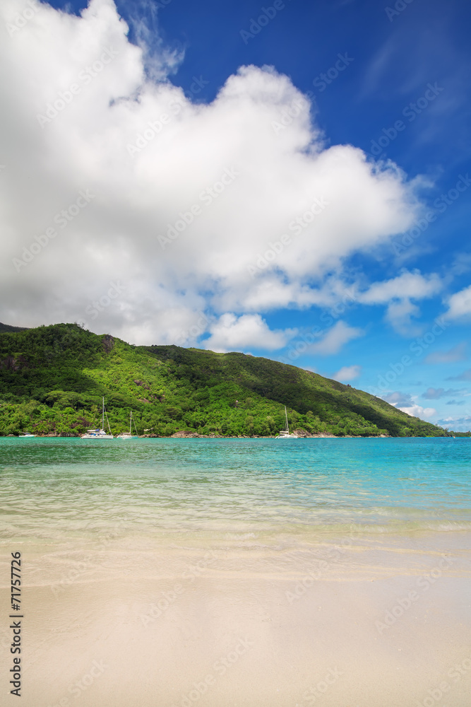 Sandy beach with green hill and blue sky background at Ephelia r