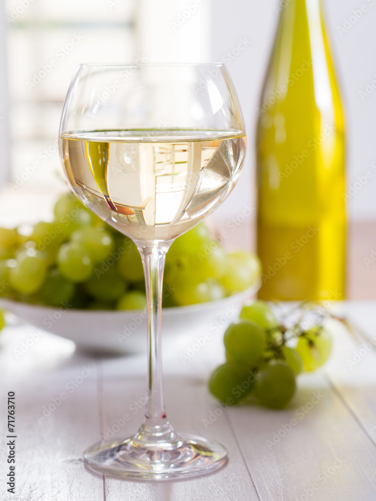 Fototapeta premium Ein Glas Weisswein mit Weintrauben