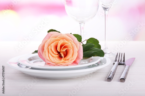 Table setting with pink rose on plate
