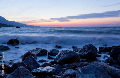 Sea landscape with stones and waves before sunrise
