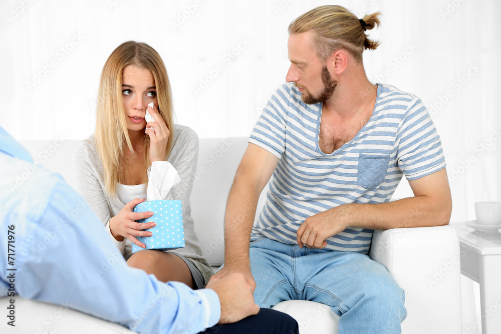 Unhappy couple not talking on couch at therapy session