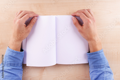 Men reading empty open book on wooden table background