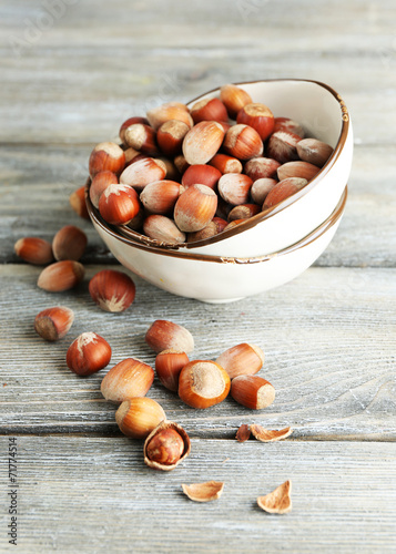 Hazelnuts in bowl on wooden background