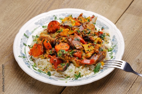 Lamb ragout with vegetables and rice in white plate
