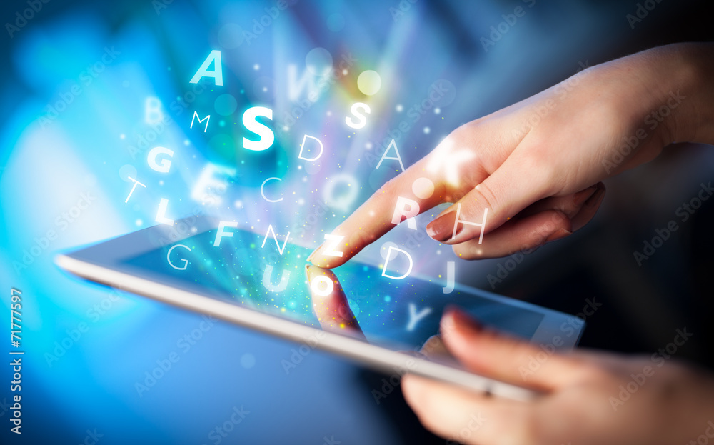 Finger pointing on tablet pc, letters concept Finger pointing on tablet pc, letters concept