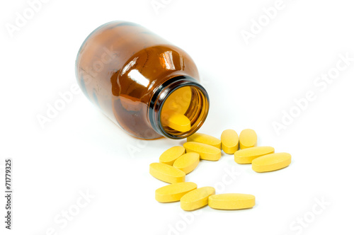 Vitamin C tablets flowing from a container
