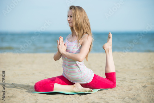Young lady practicing yoga. Workout near ocean sea coast. © mr.markin