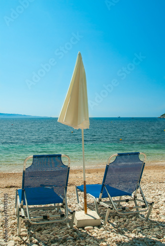 Fototapeta Naklejka Na Ścianę i Meble -  Sunbeds with umbrellas on a beautiful beach with clear water