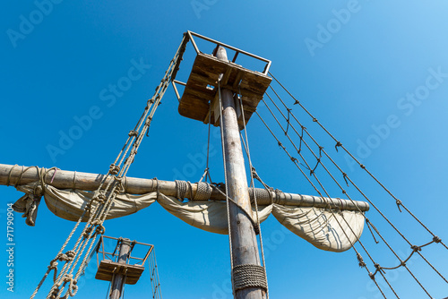 Foto Mast of wooden sailing ship, old rigging on blue sky background