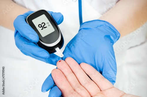 Doctor woman measuring glucose level blood in hospital close-up