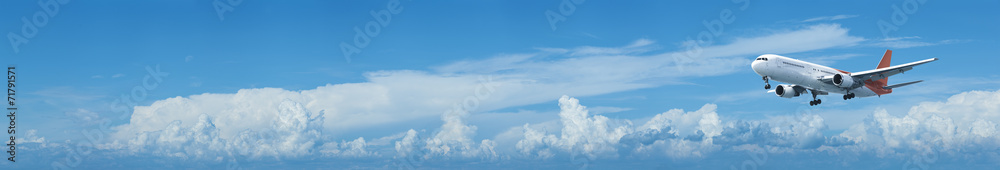 Fototapeta premium Samolot odrzutowy w błękitne niebo pochmurne