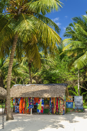 Beach with covered with a thatched roof hut with souvenirs