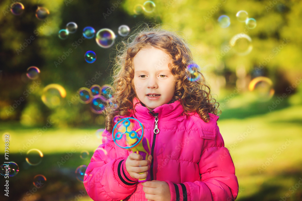 A little girl blowing soap bubbles A little girl blowing soap bubbles