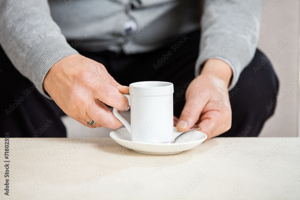 Midsection Of Senior Man Holding Coffee Cup Midsection Of Senior Man Holding Coffee Cup