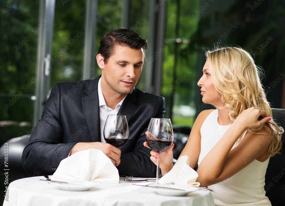 Cheerful couple in a restaurant with glasses of red wine Cheerful couple in a restaurant with glasses of red wine