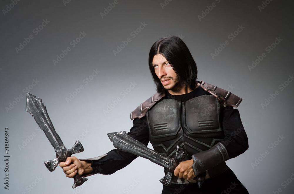 Angry knight with sword against dark background Angry knight with sword against dark background