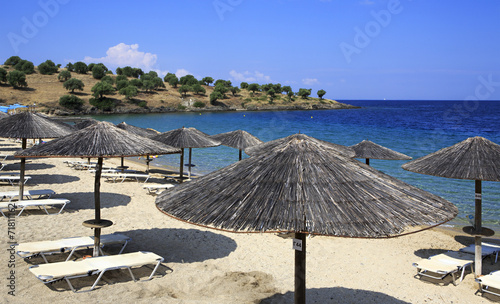 Parasols of straw on the beach of Porto Carras Grand Resort. photo