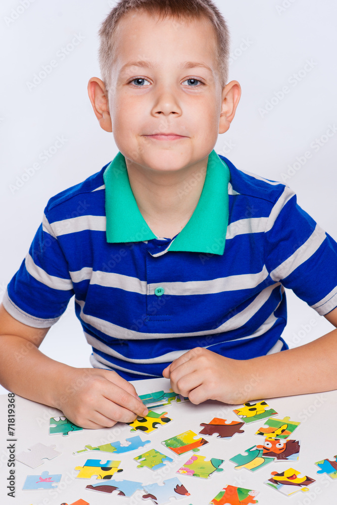 Cute little boy playing puzzles at the table Cute little boy playing puzzles at the table