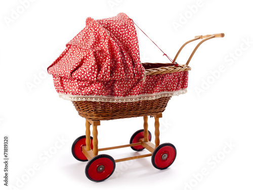 An old vintage childrens doll stroller over a white background