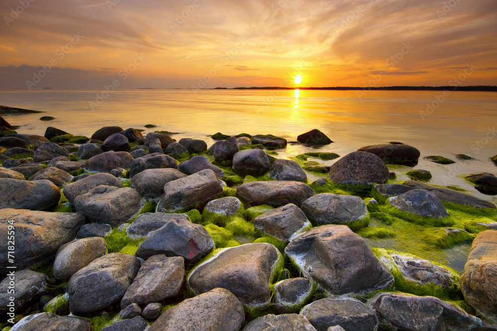 Beach rocks with still water in sunset light