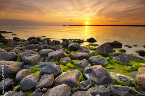 Beach rocks with still water in sunset light