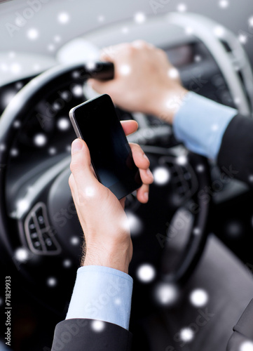 close up of man using smartphone while driving car