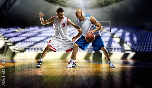Two basketball players in action in the gym