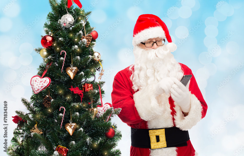 santa claus with smartphone and christmas tree santa claus with smartphone and christmas tree