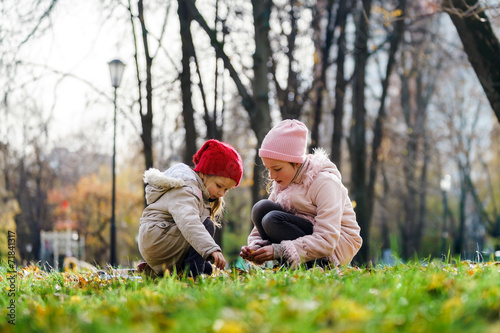 Two sisters playing in autumnal park