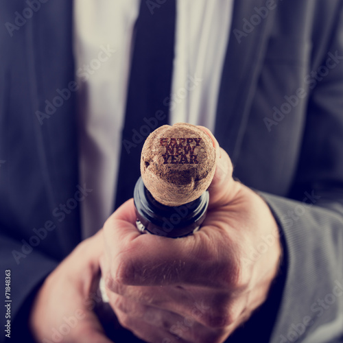 Businessman Opening Wine Bottle for New Year photo