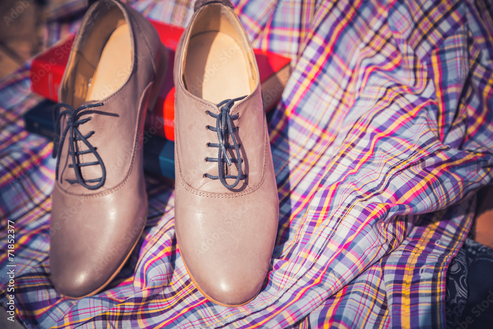 Women's leather shoes with laces are on a checkered tablecloth