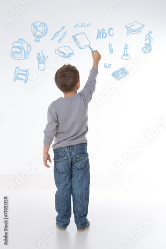 child holds a chalk in his hand