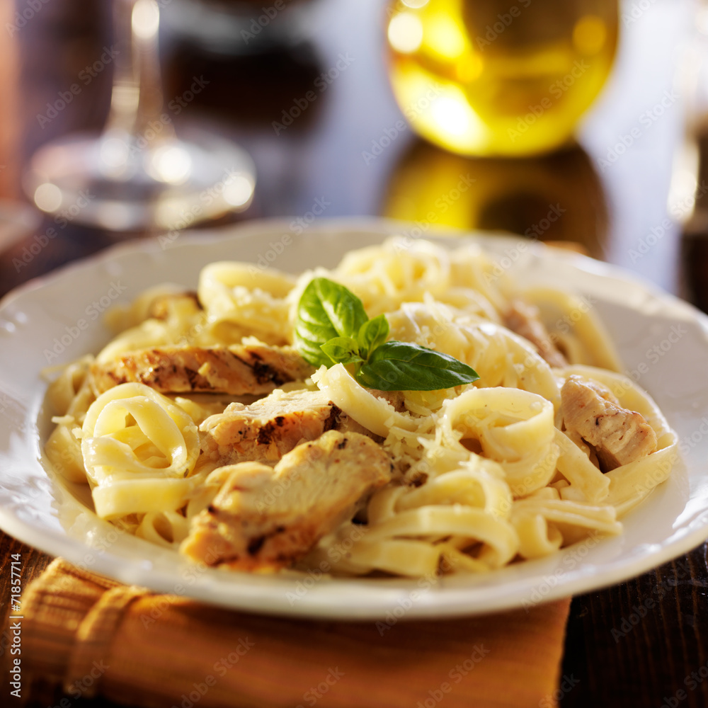 fettuccine alfredo pasta with grilled chicken at night