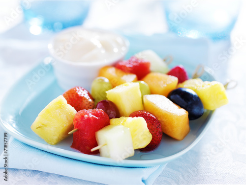 Fotografija children's fruit kabob with vanilla yogurt dip on blue plate