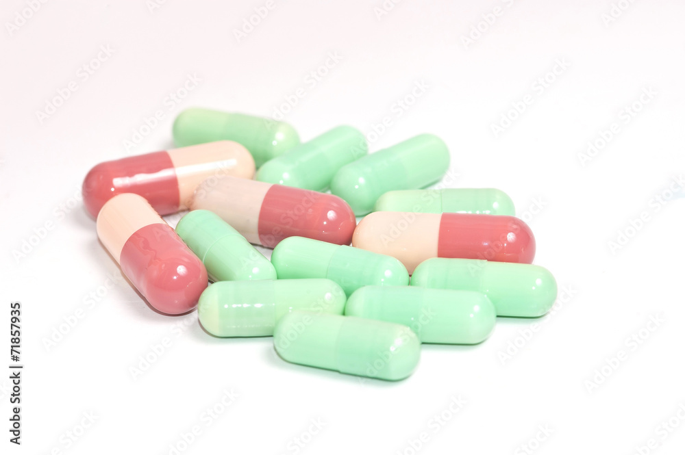 Colorful medical capsules on white background.