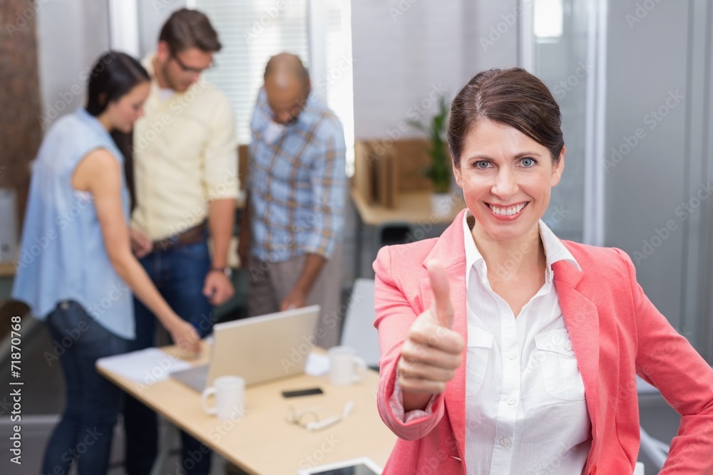 Happy businesswoman smiling at camera giving thumbs up Happy businesswoman smiling at camera giving thumbs up