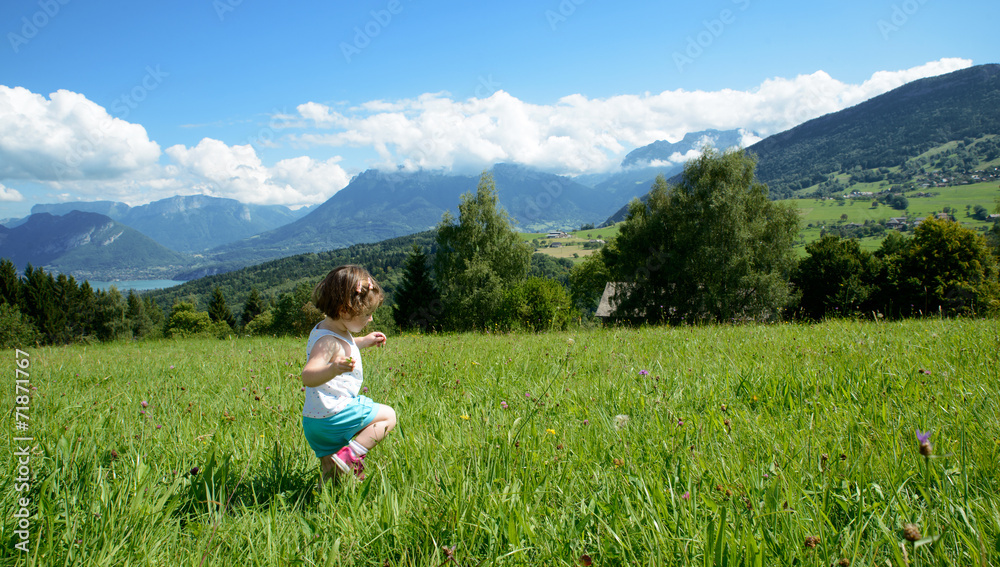 little girl playing in a meadow