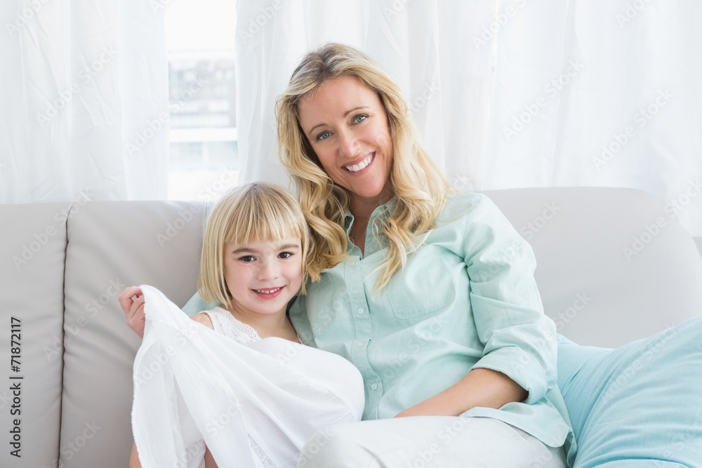 Mother sitting on the couch with her daughter Mother sitting on the couch with her daughter