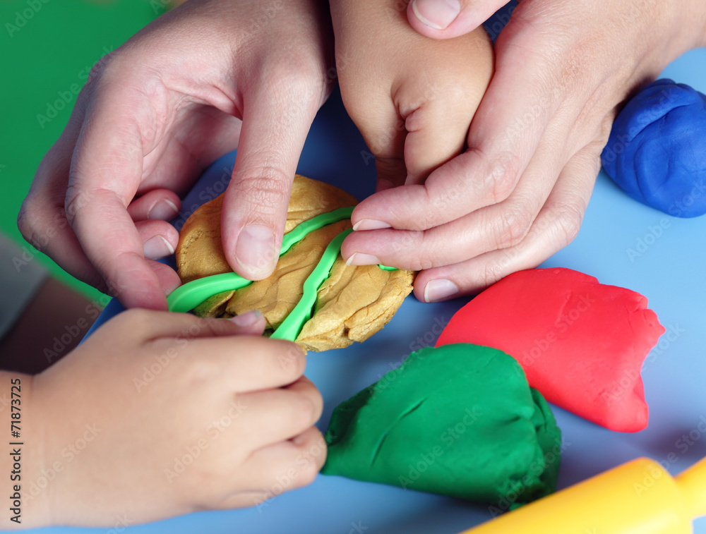 Fototapeta premium Child and mother playing with playdough