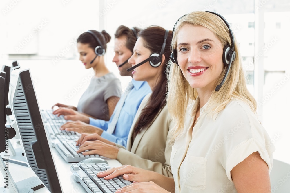 Business people with headsets using computers in office Business people with headsets using computers in office