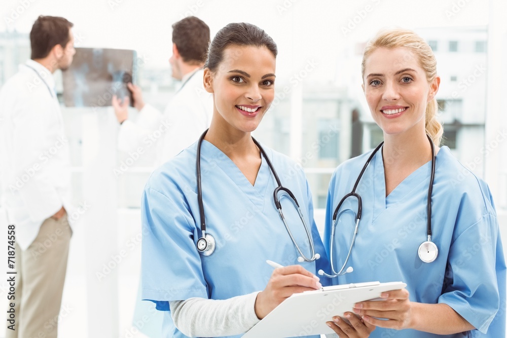 Portrait of two female surgeons with reports Portrait of two female surgeons with reports