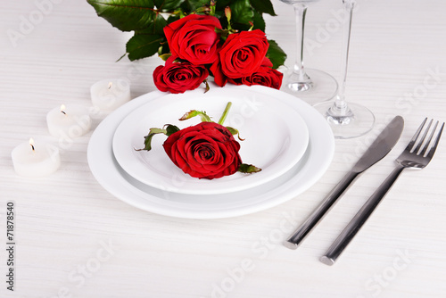 Table setting with red rose on plate
