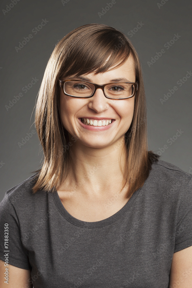 Braunhaarige Frau vor grauem Hintergrund, lachend, Portrait. Braunhaarige Frau vor grauem Hintergrund, lachend, Portrait.