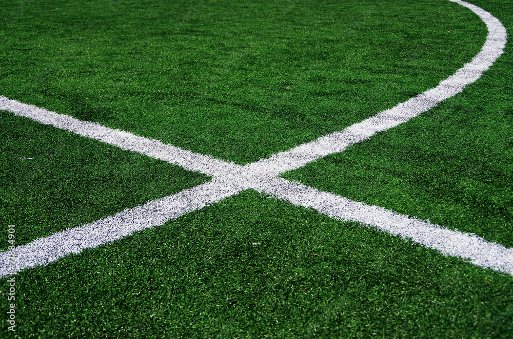 White abstract lines on a green football field.